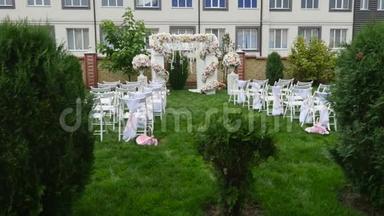 婚礼上一排排椅子。 婚庆花拱装饰.. 用鲜花装饰的婚礼拱门。 室外